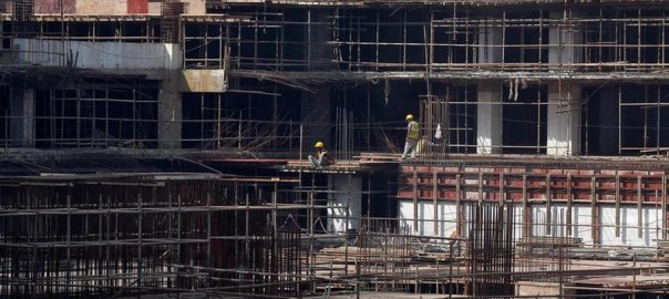 Construction workers work on a site of a residential building in Mumbai